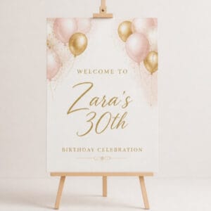 Birthday welcome sign on easel with pink and gold balloons